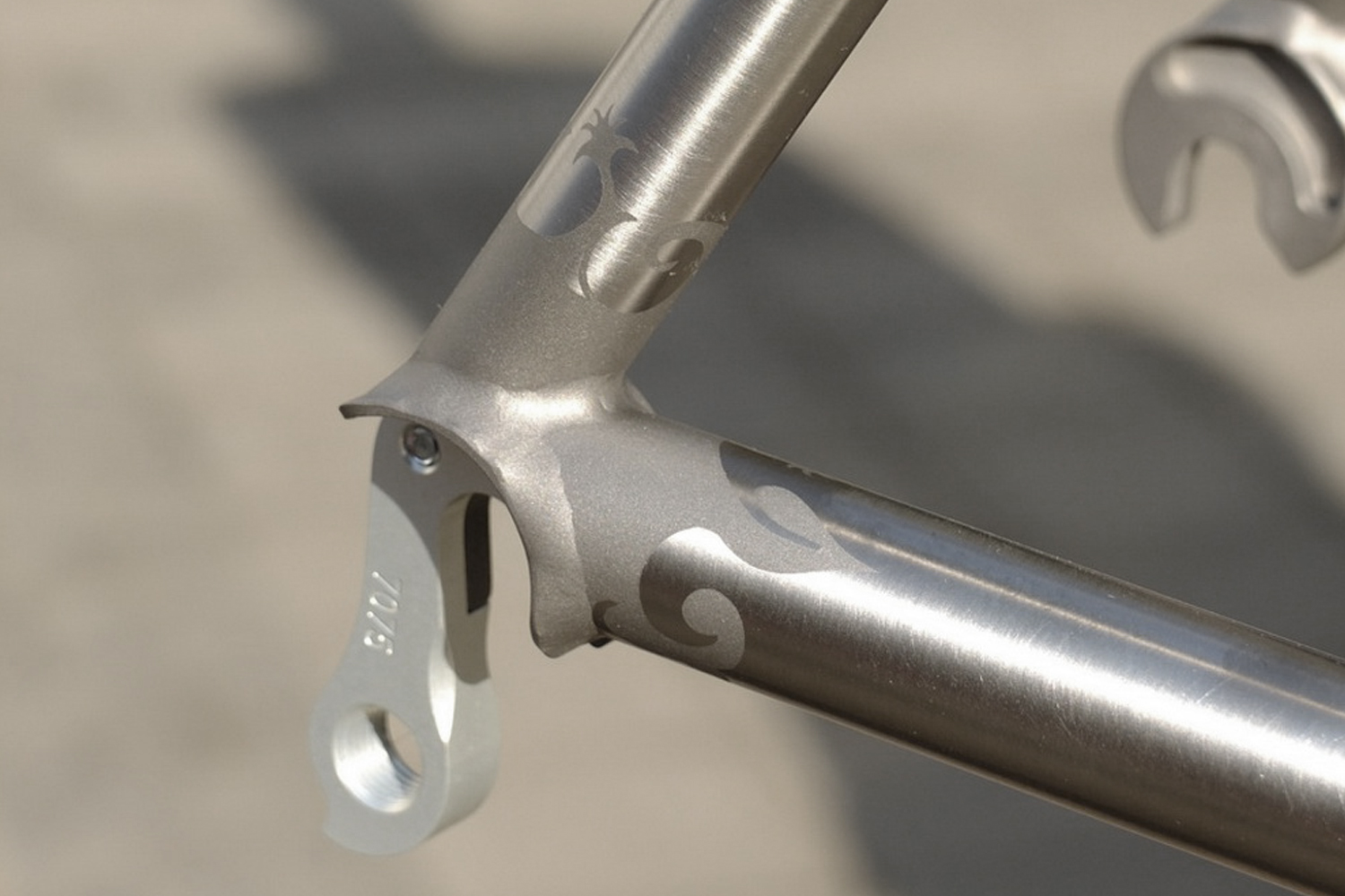 Stencil transfer on a titanium dropout marked Triton